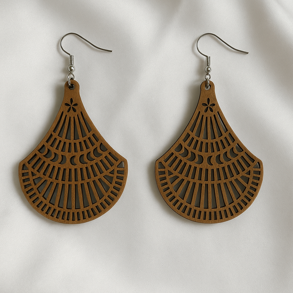 Wooden earrings with cut out design on a white fabric background