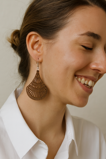 Wooden earrings with cut out design on a white fabric background